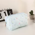 Vista detallada de un neceser de maquillaje acolchado azul claro con flores, suave. - Azul