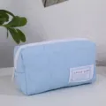 Gros plan détaillé de la trousse de maquillage matelassée bleue claire avec motif cœur. - Bleu