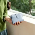 Detailed view of the light blue folding wallet showcasing multi-card slots and zipper pocket. - Beige