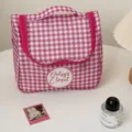 Gedetailleerd uitzicht op een roze met wit geruite cosmetische tas met handvat en ritsluiting. - Roze Wit Ruitjes
