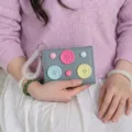 Close-up of cute dopamine color button wallet with spring wristlet, trendy minimalist design. - Light Blue