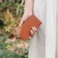 Minimalist leather golf card holder detail view, showing fine texture and dual-tone design. - Brown