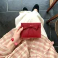 Vista di dettaglio di un porta carte rosso da donna con fiocco 3D, portafoglio compatto. - Rosso