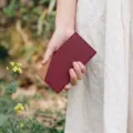 Minimalist leather card holder detail, slim design and dual-tone stitching for daily use. - Wine Red