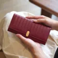 Nahaufnahme Detail der Damen Langbörde, burgunderrotes Leder mit Streifen und Verschluss. - Rot