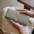 Portefeuille long pour femme élégant avec rayures verticales et fermoir doré raffiné. - Vert