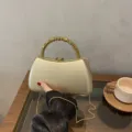 Details of luxury gold hard shell evening clutch bag with beaded handle and chain strap. - Box Bag / Gold