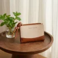 Canvas bi-fold wallet with brown leather trim and knotted strap, compact coin purse detail. - Brown