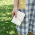 Vue détaillée du carnet à anneaux en cuir vernis blanc brillant avec un fermoir étoile. - Blanc Cassé
