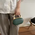 Green acrylic clutch handbag with gold metal handle and chain strap for evening party. - Dark Green