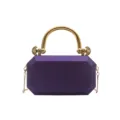 Purple acrylic box clutch detail, featuring a shiny gold metal round handle and fine chain strap. - Purple