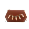 Detailed view of brown acrylic evening clutch bag with gold chain and rhinestone claws. - Brown