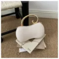 Vista dettagliata della borsa pochette in PU a forma di arachide con manico dorato e catena. - Beige