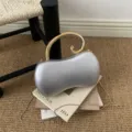 Hermoso bolso de mano plateado en forma de maní con asa dorada y elegante cadena. - Plateado