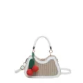 Gros plan détaillé du sac à main en paille tissée avec bordure en cuir blanc et pendentif cerise. - Style 2 blanc cassé avec pendentif
