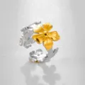 Primer plano detallado del anillo floral de acero inoxidable bicolor con textura fina. - Estilo Flor Hoja Bicolor