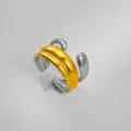 Primer plano detallado del moderno anillo abierto de acero inoxidable con acabado bicolor brillante. - Estilo 3D Aerodinámico Bicolor