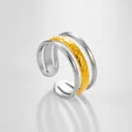 Primer plano detallado del anillo abierto multicapa con diseño texturizado en oro y plata. - Estilo Textura Martillada Multi Capa Bicolor