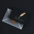 Schwarze Grußkarte mit goldener Prägung Feder Design und transparentem Umschlag für Geschenke. - Feder