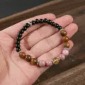 Primo piano dettagliato di un bracciale con perle in pietra naturale e cristalli misti. - Ossidiana Occhio di Tigre