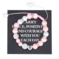 Detail view of handmade pink pearl beaded bracelet with stainless steel letter T heart charm. - Letter T