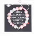 Handmade pink and white pearl bracelet detail featuring stainless steel letter S charm. - S