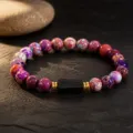 Close-up detail of colorful beaded bracelet with central black stone and gold spacer rings. - 6mm Beads / Imperial Multi-color Black Tourmaline