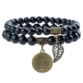 Detailed view of black natural stone double strand beaded bracelet with vintage bronze tree pendant. - Black Agate