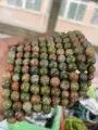 Primer plano detallado de hilos de cuentas de piedra natural multicolor con textura única. - 4mm (aprox. 90pcs) / Unakita