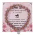 Braccialetto di perle in pietra rosa naturale con ciondolo a cuore su carta floreale. - Con Carta Confezione / Cuori con venature di legno rosso