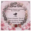 Dettaglio in primo piano del bracciale di perle in pietra zebrata rosa su carta floreale. - Con Carta Confezione / Rosso zebrato rosa