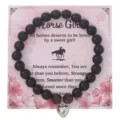 Braccialetto di perle nere con ciondolo a cuore in argento su carta floreale rosa. - Con Carta Confezione / Occhio di tigre opaco cuore