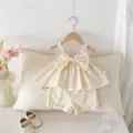 Vista dettagliata del completo estivo da bambina con top a fiocco e pantaloncini abbinati. - 73cm / Top E Pantaloni / Albicocca