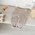 Close-up detail of infant striped ribbed leggings, casual comfortable style for baby girls. - 66cm / Coffee