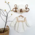Adorabile tutina neonato a maniche lunghe con delicato bordo in pizzo e cappellino abbinato. - Tutine albicocca