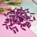 Close-up detail view of purple rectangular flatback rhinestones for craft garment decoration. - Purple Rose Red