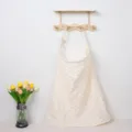 Close-up view of breathable double gauze nursing cover hanging neatly on wooden wall hook. - Bow Knot with Wooden Ring