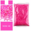 Primo piano dettagliato di strass in resina rosa lucidi, perfetti per nail art fai-da-te e custodie. - Rosso rosa