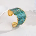 Detailed shot of wide C-shaped open cuff bracelet with green abalone pattern and gold edge. - Green