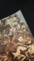 Close-up of fluid water ripple special paper sheet, metallic holographic badge backing texture - Copper