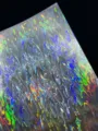 Holographic laser cardstock detail showcasing iridescent flame pattern for crafts and badges. - Golden Betta Fish