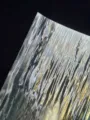 Close-up detail shot of holographic laser backing paper showing shimmering ripple texture. - Ripple Texture