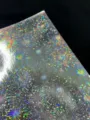 Holographic laser specialty cardstock detail, shiny fireworks pattern paper for crafts and badges. - Fireworks