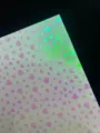 Detail view of holographic glitter specialty paper featuring cute heart pattern for DIY crafts. - Red Heart Glow