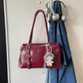 Retro bordeaux rode schoudertas voor dames met grote capaciteit en een schattige pluche poppenhanger. - Rood
