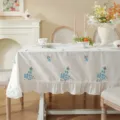 White cotton embroidered tablecloth with blue floral pattern and ruffled edge for dining table. - Embroidered Peach Blossom Blue with Ruffled Edge (Waterproof)