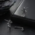 Detailed view of vintage silver cross earrings with zircon details, retro punk style men jewelry. - Fleur-De-Lis Cross Earrings Pair / Worn Silver