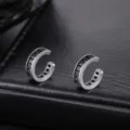 Primer plano detallado de pendientes plateados con circonitas negras sobre cuero - Puño Cobre Strass Negro (X1360-B) / 1 Pieza/Paquete / Negro