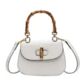 Elegante bolso de cuero blanco con asa de bambú distintiva y cierre elegante y chic. - Blanco