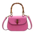Elegante bolso de hombro de cuero rosa con asa de bambú y cierre giratorio chic. - Rosa